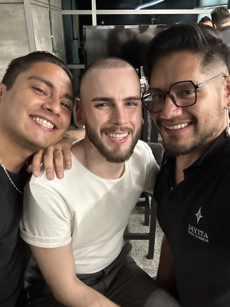 Tres asistentes sonriendo en una selfie